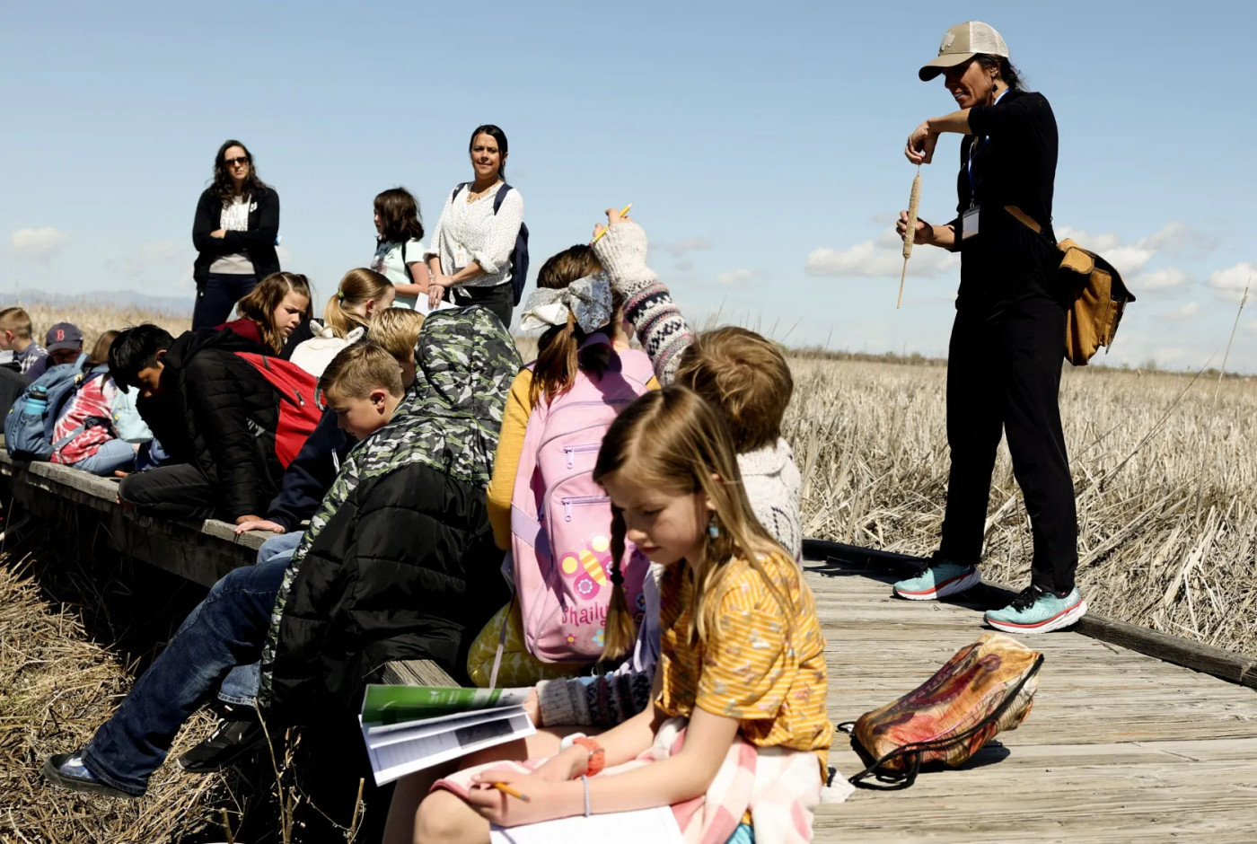 Volunteer naturalist Kristen Bonner, right, shows Creekside Elementary students a cattail at the Great Salt Lake Shorelands Preserve as part of The Nature Conservancy’s Wings & Water program in Layton on Wednesday, April 20, 2022.Laura Seitz, Deseret News
